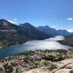 Panoramic view of Waterton Lakes with mountains and village.