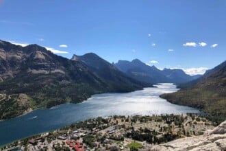 Panoramic view of Waterton Lakes with mountains and village.