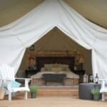 Elegant Glamping Tent with Plush Bedding and Outdoor Seating