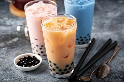 Assorted bubble milk tea flavors in glasses with tapioca pearls.