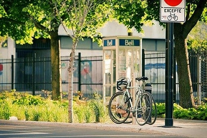 Bicycle parked on Montreal city street with greenery.