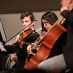 Orchestra musicians performing classical music live.