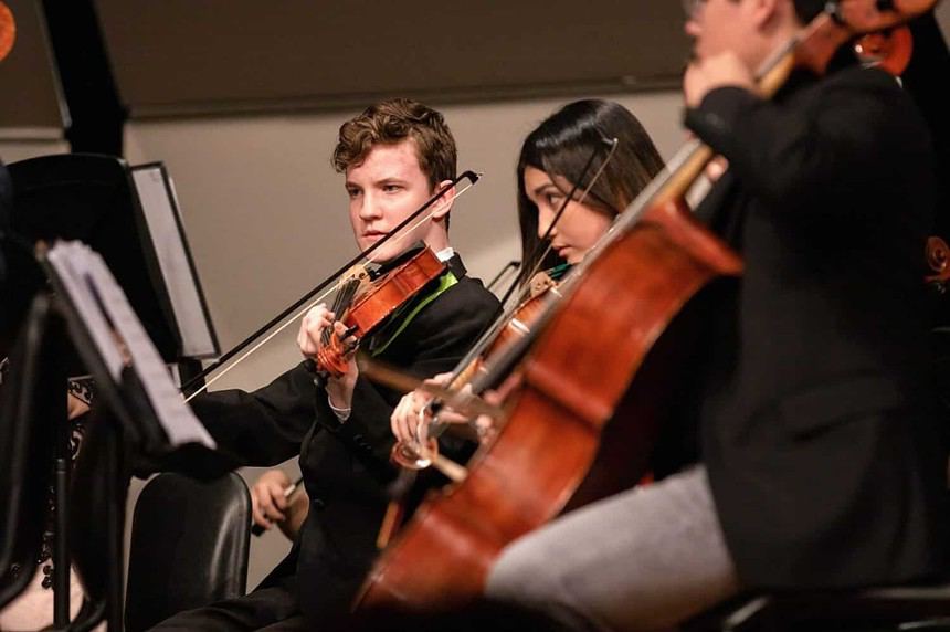 Orchestra musicians performing classical music live.