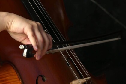 Close-up of a musician playing a classical cello.