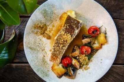 Elegant plated sablefish with vegetables and garnish.