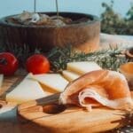 Cheese and ham platter with fresh tomatoes.