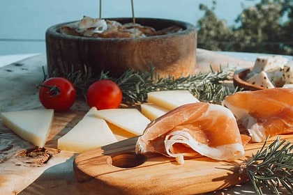 Cheese and ham platter with fresh tomatoes.