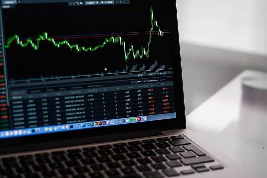 Laptop displaying stock market investment charts.