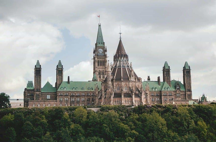 Historic stone building with towers against cloudy sky.