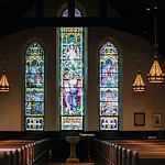 Elegant stained glass windows in a serene church interior.