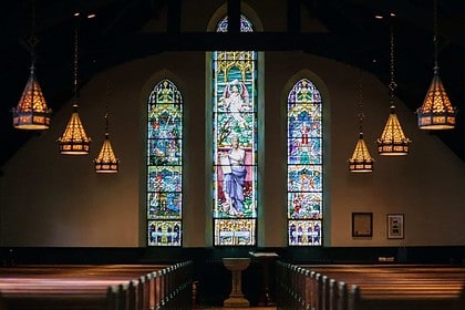 Elegant stained glass windows in a serene church interior.