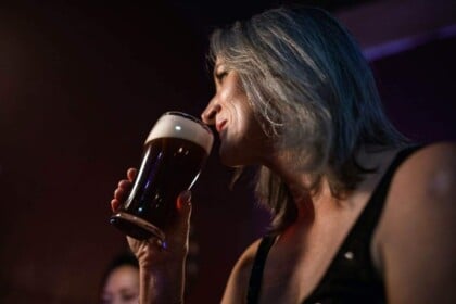Woman enjoying craft beer in Toronto bar.