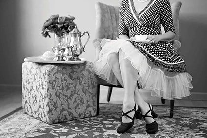 Elegant vintage tea party attire and setting.