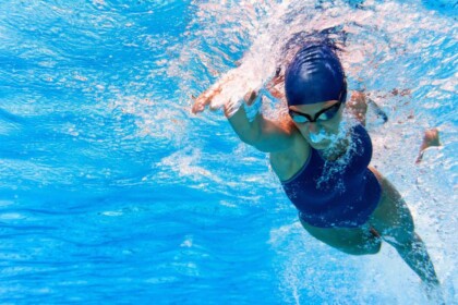 Female athlete performing freestyle stroke in swimming pool.