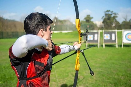 Archer practicing at outdoor archery range.