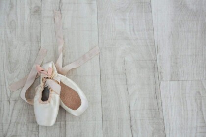 Ballet pointe shoes on wooden floor.
