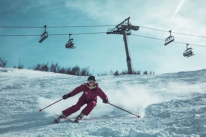 Skiing action on snowy mountain slope with chairlifts.