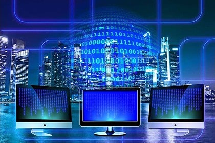 Binary code on monitors with futuristic cityscape background.
