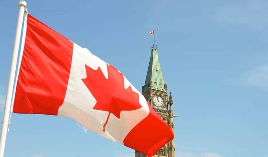 Canadian flag waving in front of Parliament Hill.