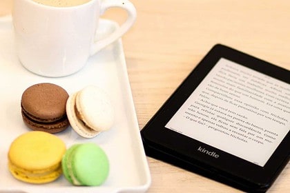 Ebook, coffee, and macarons on a study table.