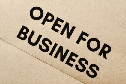 Open for Business sign on textured background.