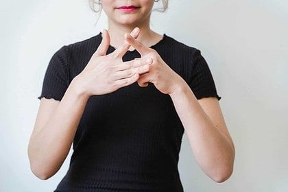 Woman practicing sign language basics.