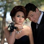 Teen couple dressed up for prom, posing outdoors.