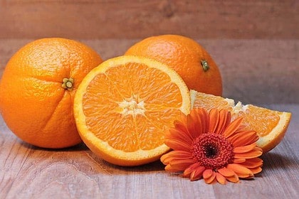 Oranges and flower symbolizing Vitamin C skincare benefits.