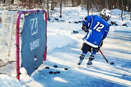 Outdoor ice hockey practice in winter setting.