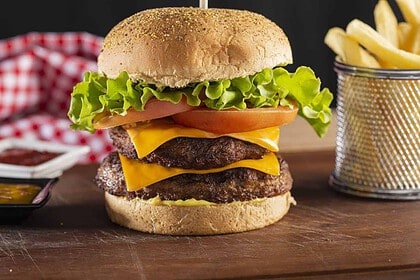 Cheeseburger with lettuce, tomato, and fries on side