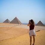 Tourist taking photos of the Giza Pyramids in Egypt.