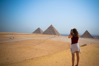 Tourist taking photos of the Giza Pyramids in Egypt.