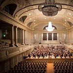 Elegant opera house interior with audience and orchestra.
