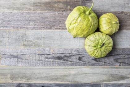 Fresh tomatillos on rustic wood background.