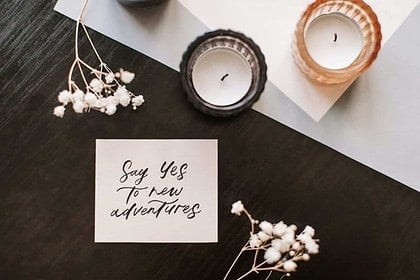 Calligraphy materials with inspirational quote and candles.