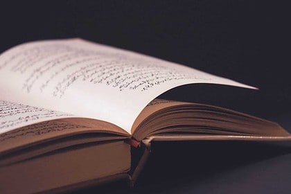 Open Urdu language learning book on table.