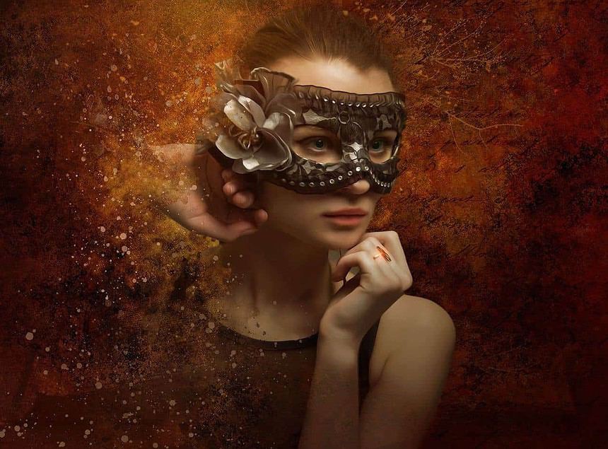Elegant woman wearing a decorative mask with a thoughtful expression.