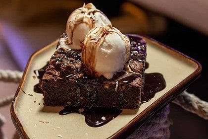 Decadent brownies with ice cream topping.