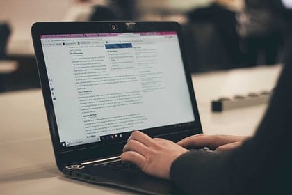 Person typing on a laptop in a class.
