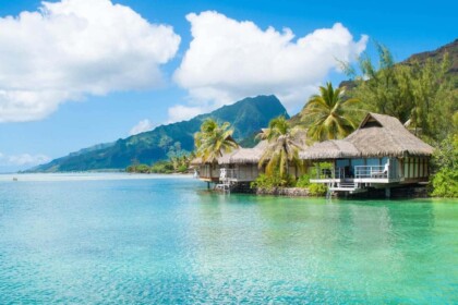 Idyllic Tahiti beach bungalows on crystal-clear water.
