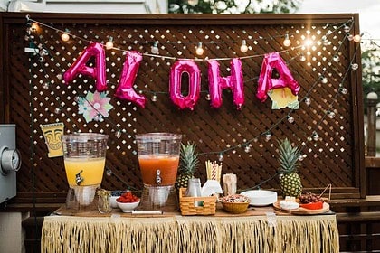 Hawaiian Aloha party decorations and tropical drinks setup.