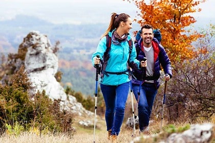 Couple enjoying a scenic autumn hike with gear.