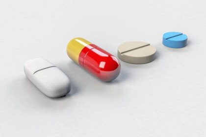 Assorted dietary supplement pills on white background.