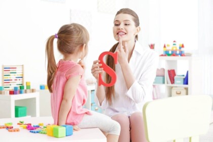 Child practicing speech therapy with professional