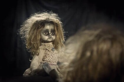 Creepy haunted doll, mysterious horror theme, Ottawa attraction.
