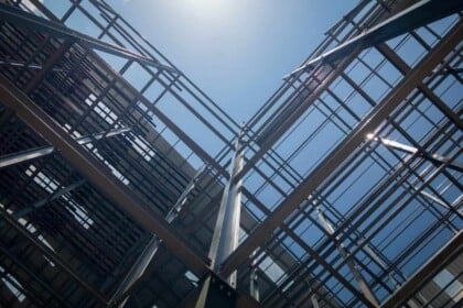 Modern steel framework of building under blue sky.