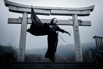 Samurai sword practice at a torii gate in misty surroundings.