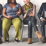 Diverse team engaged with laptops and mobile devices.