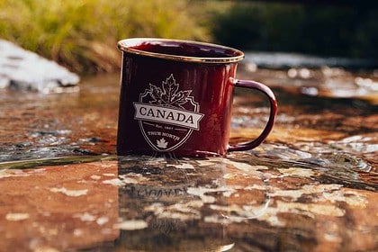 Canada souvenir mug on rocky surface.