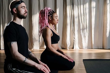 Couple practicing peaceful meditation together indoors.
